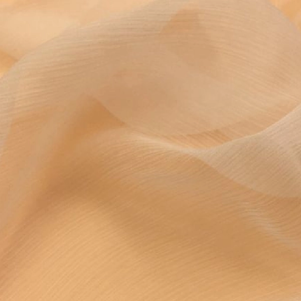 Sheer, flowing light orange fabric with gentle ripples and visible translucence, allowing light to softly pass through