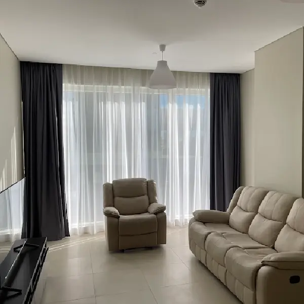 White sheer curtains hanging in front of a window, allowing light to filter into the room.