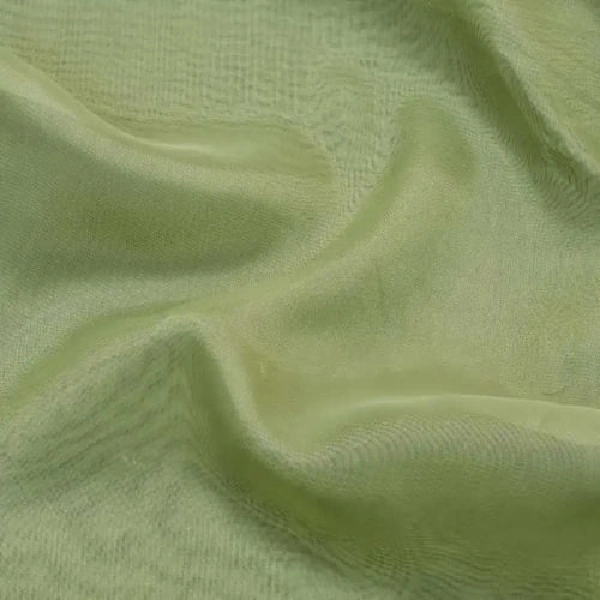 A close-up of light green, sheer curtain fabric with subtle folds and a fine texture.