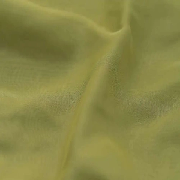A close-up of light green, sheer curtain fabric with subtle folds.