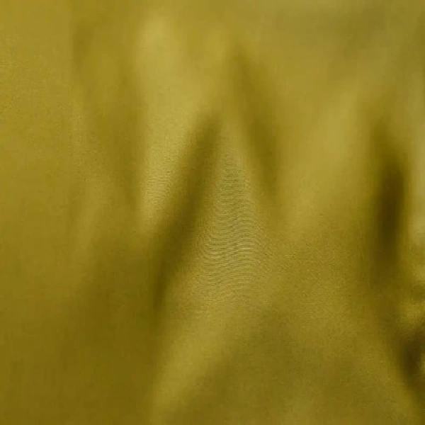 A close-up of shiny, green curtain fabric with soft folds. (1)
