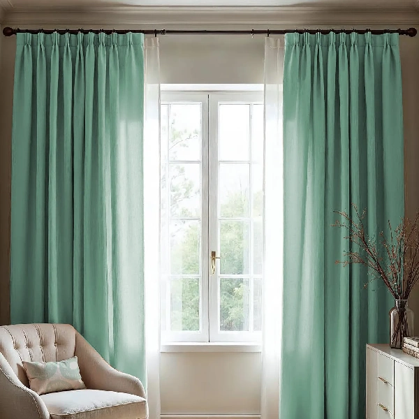 Pinch pleat curtains in a light teal color.
