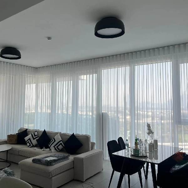 large windows covered in white sheer wave fold curtains