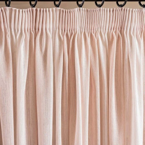 light pink pencil pleat curtain, showing the gathers at the top.